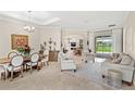 Bright, open-concept living area with elegant furnishings, tile floors, and access to the outdoor patio at 31754 Red Tail Blvd, Sorrento, FL 32776