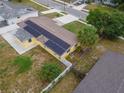 Aerial view of a home with solar panels, fenced yard, mature trees, and convenient street access at 3300 Needles Dr, Orlando, FL 32810