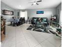 The bright living room has neutral decor, tile floors, and flows into the dining area at 3620 Benson Park Blvd, Orlando, FL 32829