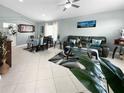 Well-lit living room featuring tile flooring, a comfortable sofa, and an adjacent dining area at 3620 Benson Park Blvd, Orlando, FL 32829