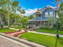 Charming two-story home with a spacious porch, manicured lawn and mature trees at 420 S Oak Ave, Sanford, FL 32771