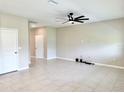 Spacious living room with neutral tones, tiled floor, and a modern ceiling fan at 6268 Great Bear Dr, Lakeland, FL 33805
