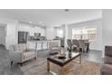 Bright, open-concept living room flows into a modern kitchen and dining area, featuring neutral tones and stylish furnishings at 6328 Whip O Will Ln, St Cloud, FL 34771