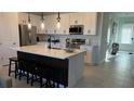 Modern kitchen features an island with bar seating and stainless appliances at 639 Longboat Dr, Davenport, FL 33896