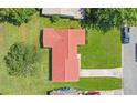 Aerial view of a home with a red tile roof, surrounded by a green lawn and neighboring houses at 10148 Eventide Ct, Orlando, FL 32821