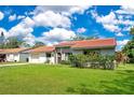 A cozy single-story home with a red tile roof, neat landscaping, and a well-kept green lawn at 10148 Eventide Ct, Orlando, FL 32821