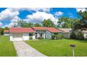 Inviting single-story home with a red-tiled roof, lush lawn, and driveway to the attached garage at 10148 Eventide Ct, Orlando, FL 32821