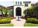 Elegant front entry with wrought iron door accents, a water feature, and well-maintained landscaping at 11013 Ullswater Ln, Windermere, FL 34786