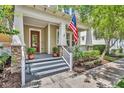 Inviting front porch with stone accents, classic columns, a stylish front door, and manicured landscaping at 1356 Coralstone Dr, Celebration, FL 34747