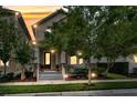 Charming two-story home at twilight featuring a covered front porch with classic columns and a well-manicured front yard at 1356 Coralstone Dr, Celebration, FL 34747