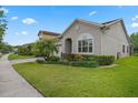 Street view of a well-maintained home with a lush green lawn, complemented by a paved driveway and thoughtful landscaping at 14072 Alafaya Oak Bnd, Orlando, FL 32828