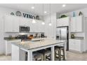Bright, modern kitchen features a granite island with seating, stainless steel appliances, and ample cabinet space at 14072 Alafaya Oak Bnd, Orlando, FL 32828