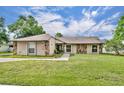 Charming home featuring stone accents, a well-manicured lawn, and welcoming walkway at 150 Tarpon Cir, Winter Springs, FL 32708