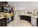 Modern kitchen with stainless steel appliances, dark cabinetry, and a seamless flow to the dining area at 1501 Prairie Oaks Dr, St Cloud, FL 34771