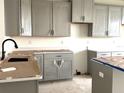 Unfinished kitchen featuring modern gray cabinets, black hardware, and light countertops at 15083 Grove Lake Dr, Winter Garden, FL 34787