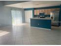 Open-concept kitchen and living area with tile floors and stainless steel appliances at 1921 Stone Abbey Blvd, Orlando, FL 32828