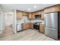 Updated kitchen featuring stainless steel appliances, wood cabinets, quartz counters, and modern flooring at 1957 Deloy Dr, Daytona Beach, FL 32119