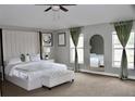 Stylish bedroom with upholstered headboard, tufted ottoman, and arched wall mirror at 2381 Courtland Blvd, Deltona, FL 32738