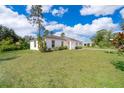 A charming single-story house with white exteriors surrounded by a well-maintained lawn and landscaping at 2498 Iris Rd, Deland, FL 32724