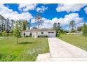 Inviting single-story home with a well-maintained lawn, long driveway, and an attached one car garage at 2498 Iris Rd, Deland, FL 32724