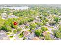 Aerial view of a residential neighborhood with lush greenery and a lake nearby at 254 Oak Park Pl, Casselberry, FL 32707