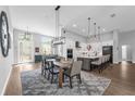 Open-concept dining area featuring modern lighting and seamlessly connects to the kitchen and living spaces at 2643 University Acres Dr, Orlando, FL 32817