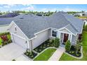 Charming single-story home with well-manicured landscaping, a two car garage, and a covered entryway at 2941 Marlberry Ln, Clermont, FL 34714