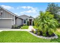 Single-story home with manicured landscaping, a two car garage, sidewalk, and a covered entryway at 2941 Marlberry Ln, Clermont, FL 34714