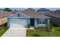 Charming single-Gathering home showcasing a well-manicured lawn and attached two car garage at 3354 Aruba Way, Haines City, FL 33844