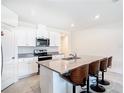 Bright, modern kitchen features an island with bar seating and stainless steel appliances at 3354 Aruba Way, Haines City, FL 33844