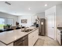 Modern kitchen with stainless steel appliances, an island, and an adjacent dining area at 3354 Aruba Way, Haines City, FL 33844