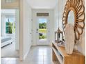 Inviting entryway with a decorative mirror, neutral tiles, and a bright view of the outdoors at 33612 Seattle Slew Dr, Sorrento, FL 32776