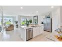 Bright, open-concept kitchen with stainless steel appliances, granite countertops, and an island with a sink at 33612 Seattle Slew Dr, Sorrento, FL 32776