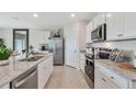 Modern kitchen with stainless steel appliances, granite countertops, and white cabinetry at 33612 Seattle Slew Dr, Sorrento, FL 32776