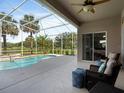 Relaxing outdoor patio area with comfortable seating, overlooking a private screened-in pool and lush landscaping at 3840 Caledonia Ave, Apopka, FL 32712