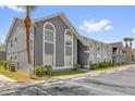 Gray condominium building exterior showcasing clean lines and large windows with lush landscaping at 4160 Pershing Pointe Pl # 4, Orlando, FL 32822