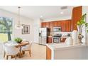 Bright kitchen with stainless steel appliances, cherry cabinets, and an adjacent breakfast nook with a view at 4301 Heirloom Rose Pl, Oviedo, FL 32766