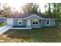 A single-story home with a blue exterior, a one-car garage, and a freshly laid lawn at 4919 Nw 61St Ct, Ocala, FL 34482
