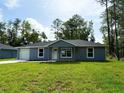 Charming one-story home featuring a well-maintained lawn, attached garage, and inviting front entrance at 4919 Nw 61St Ct, Ocala, FL 34482
