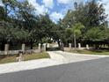 Long driveway leading to a gated property with mature trees and landscaped grounds offering seclusion at 4981 Lake Cecile Dr, Kissimmee, FL 34746