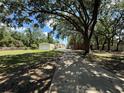 Long driveway leading to home and detached garages on large lot with mature landscaping at 4981 Lake Cecile Dr, Kissimmee, FL 34746