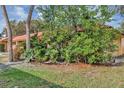 Exterior shot showcasing lush landscaping surrounding the property with a red tile roof at 5039 Jamaica # 10, Orlando, FL 32808
