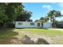 Single-story home with a lush lawn and mature trees creating a serene landscape at 707 N Solandra Dr, Orlando, FL 32807