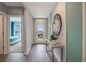 Welcoming entryway with wood flooring, a decorative mirror, and view into a bedroom at 746 Mocking Jay Ln, St Cloud, FL 34771
