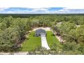 Stunning aerial view of a modern home surrounded by lush greenery and a long driveway at 8202 Sw 123Rd Ter, Dunnellon, FL 34432