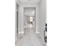 Inviting hallway featuring light wood floors leading to a sunlit living area at 8202 Sw 123Rd Ter, Dunnellon, FL 34432