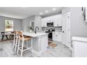 Modern kitchen with white cabinets, stainless steel appliances, and island seating at 8202 Sw 123Rd Ter, Dunnellon, FL 34432