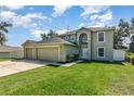 Inviting two story home featuring an attached three car garage and a well manicured lawn at 9532 Water Fern Cir, Clermont, FL 34711