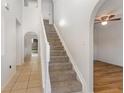 Bright foyer with tile flooring, staircase, and arched doorways at 9532 Water Fern Cir, Clermont, FL 34711
