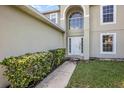 Charming front door entrance with beautiful greenery and a well-maintained walkway at 9532 Water Fern Cir, Clermont, FL 34711